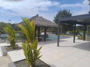 a resort with a swimming pool and a thatch roof at Six Pillars Resort in Bastimentos +4 photos
