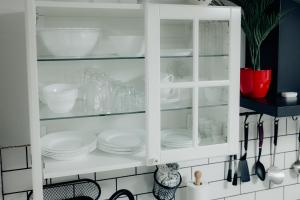 a white cabinet filled with dishes and utensils at Apartment Berglez in Škofja Loka +42 photos