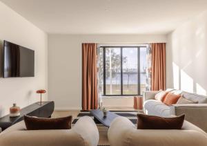 a living room with two couches and a large window at Upon Harbor - Seixal Bay Hotel in Seixal