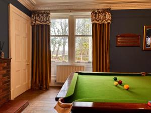 a room with a pool table in front of a window at Clashmore House in Dornoch