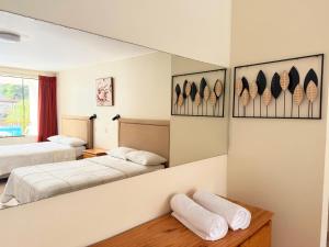 a hotel room with two beds and a mirror at Regina Hotel in Lunahuaná
