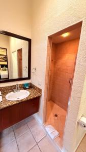 a bathroom with a sink and a shower with a mirror at Mayan Princess Beach & Dive Resort in West Bay