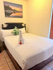a white bed with a stuffed animal on top of it at Mayan Princess Beach & Dive Resort in West Bay +154 photos