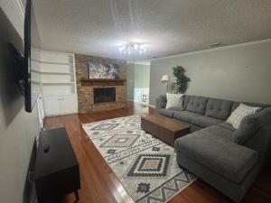a living room with a couch and a fireplace at 4-Bedroom Home with Private Pool in Euless in Euless