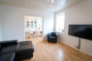 a living room with a couch and a flat screen tv at Spacious 3-Bedroom Apartment with Comfy Beds in Central Vágur, Island of Suðuroy in Vágur