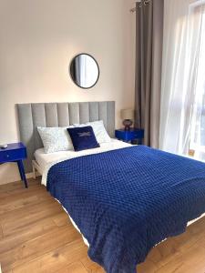 a bedroom with a large bed with a blue comforter at A63 by Real Apartment in Warsaw