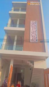 a tall building with people standing in front of it at Hotel Kanha palace in Lucknow