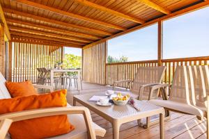 a patio with chairs and tables on a deck at Camp Panorama Plus with Pool in Drage