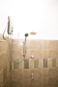 a shower in a bathroom with a phone on the wall at Meadow Villa - Ella in Ella +100 photos