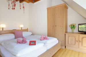 a bedroom with a bed with red and white pillows at Bauerncafé Sprengel in Bad Gandersheim