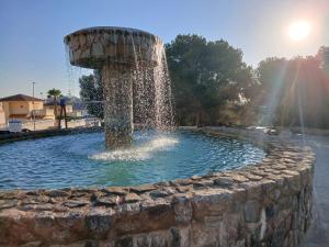 a fountain in a park with a stone wall at Apartament La Mata -Maya Bungalow in Torrevieja