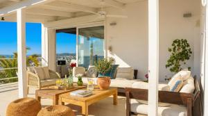 a patio with a couch and tables and chairs at Villa Sitges Altavista Amazing View South oriented Calm Area AC Beach 2 minutes Drive and 18 minutes Walk in Sitges