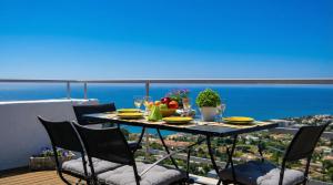 a table with plates of food on top of a balcony at Villa Sitges Altavista Amazing View South oriented Calm Area AC Beach 2 minutes Drive and 18 minutes Walk in Sitges