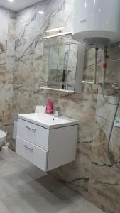 a bathroom with a white sink and a mirror at Apartmán Tonny in Jáchymov