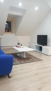 a living room with a white table and a tv at Apartmán Tonny in Jáchymov