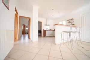a white kitchen with a counter and stools at La ferme in Moltifao