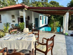 a table with plates and wine glasses on a patio at The Ellen Horizon in Baddegama