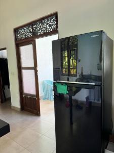 a kitchen with a sink and a refrigerator at The Ellen Horizon in Baddegama