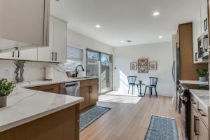 a kitchen with wooden floors and white cabinets at La Fleur Chateau 4B 2B Duplex KING Pet Friendly in Richardson