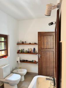 a bathroom with a white toilet and a sink at The Ellen Horizon in Baddegama +41 photos