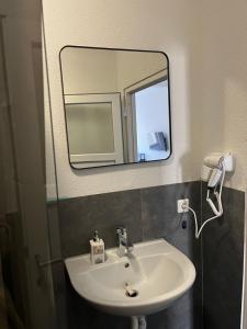 a bathroom with a sink and a mirror at Ferienwohnung Fatlume No 7 in Bad Honnef am Rhein +13 photos