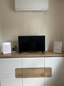 a flat screen tv sitting on top of a cabinet at Studio climatisé SPA en option in Jacou