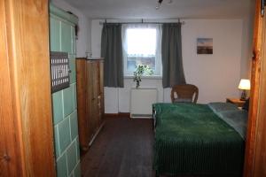 a bedroom with a green bed and a window at Kleine Auszeit Blumenthal in Ferdinandshof +19 photos