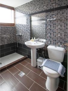 een badkamer met een toilet, een wastafel en een bad bij PINEAPPLE Skiathos in Skiathos-stad