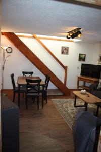 a living room with a table and chairs and a staircase at Kleine Auszeit Blumenthal in Ferdinandshof