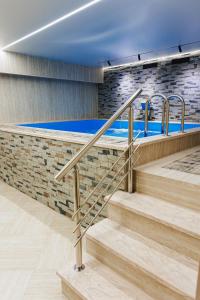 a swimming pool with stairs in a building at Beibarys Hotel in Ustʼ-Kamenogorsk