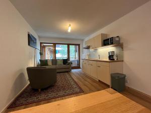 a living room with a couch and a kitchen at Gästehaus Math in Oberstdorf