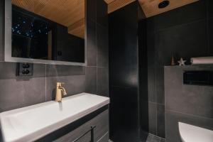 a bathroom with a white sink and a mirror at Lapland Glow Chalets in Rovaniemi