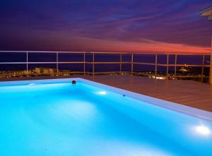 a swimming pool on top of a balcony at night at Villa Sitges Altavista Amazing View South oriented Calm Area AC Beach 2 minutes Drive and 18 minutes Walk in Sitges