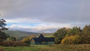 a green house in the middle of a field at Oak Hill Escape in Welshpool