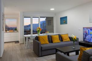 a living room with a couch and a table with yellow pillows at Villa Aster in Privlaka