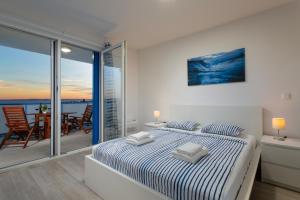 a white bedroom with a bed and a balcony at Villa Aster in Privlaka +19 photos
