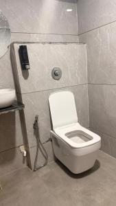 a bathroom with a white toilet and a sink at Hotel M S Gold Ganadhinagar in Gandhinagar