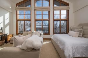 a bedroom with a bed and a couch and windows at Colonnade Residence 11 in Ketchum