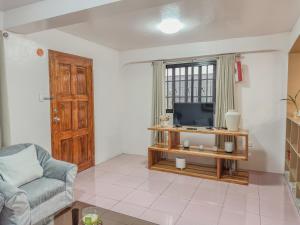 a living room with a tv and a chair at La-Rivière Vacation Home in Lal-lo