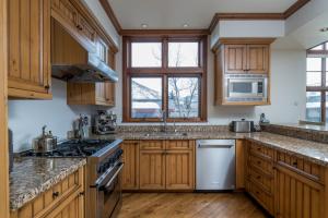 a kitchen with wooden cabinets and stainless steel appliances at Colonnade Residence 11 in Ketchum