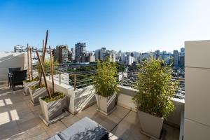a balcony with potted plants and a view of a city at Urban Suites Recoleta Boutique Hotel in Buenos Aires