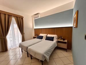 a bedroom with two beds and a large window at Hotel Al Faro in Licata