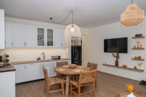 a kitchen and dining room with a table and chairs at Maelia Samos Apartment in Ríva +19 photos