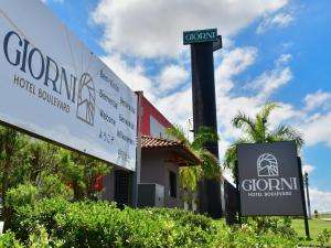 a sign in front of a building with a street sign at Giorni Hotel Boulevard in Resende +86 photos