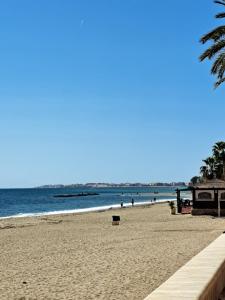 a sandy beach with people in the water at Aguadulce Beach in Aguadulce