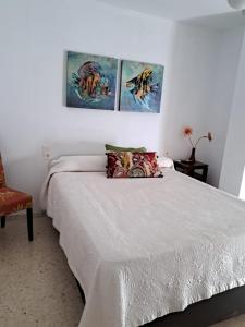 a bedroom with a bed and three paintings on the wall at Aguadulce Beach in Aguadulce