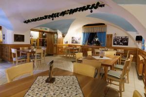 a restaurant with wooden tables and chairs in a room at Guesthouse Veles in Slovenska Bistrica