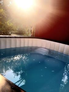 a pool of water with the sun in the background at Domaine d'Avalon in Lorgues