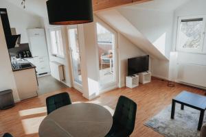 a living room with a table and a kitchen at FeWo Kibo Kupferberg in Kirchheimbolanden