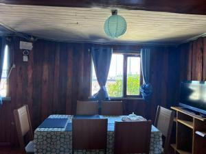 a dining room with a table and chairs and a television at MiraMar Casa Azul in Puerto Saavedra